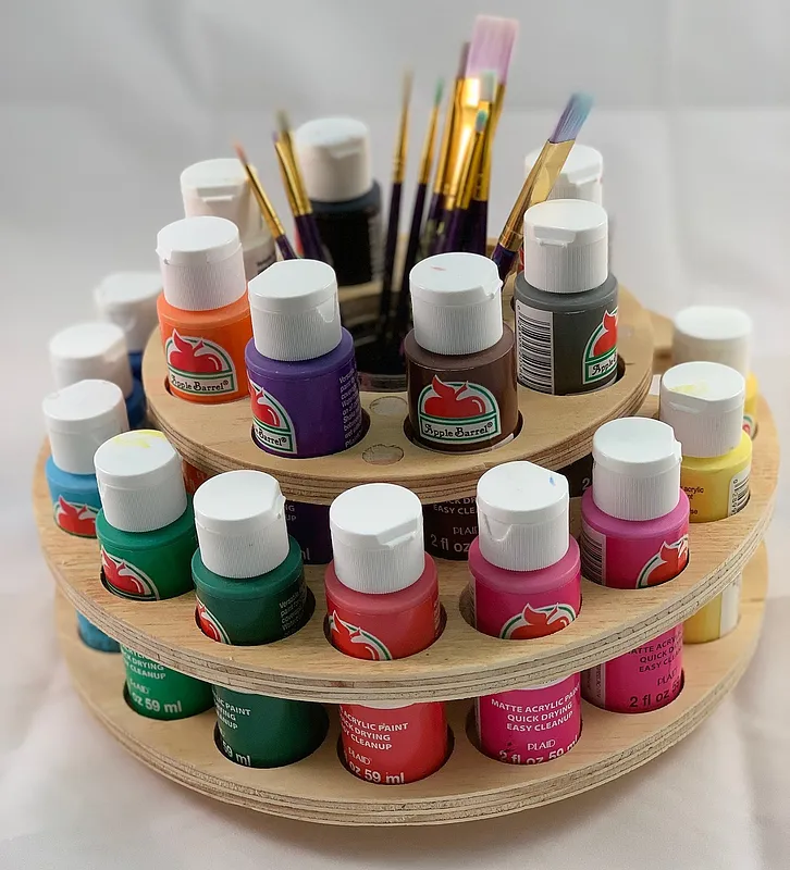 Plywood paint carousel holding acrylic paint bottles and brushes