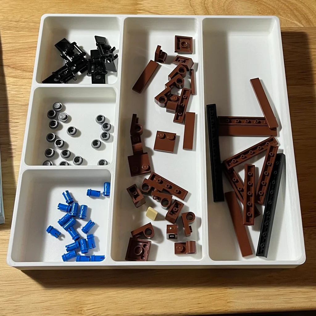 White printed parts trays holding sorted screws, hardware, and small parts