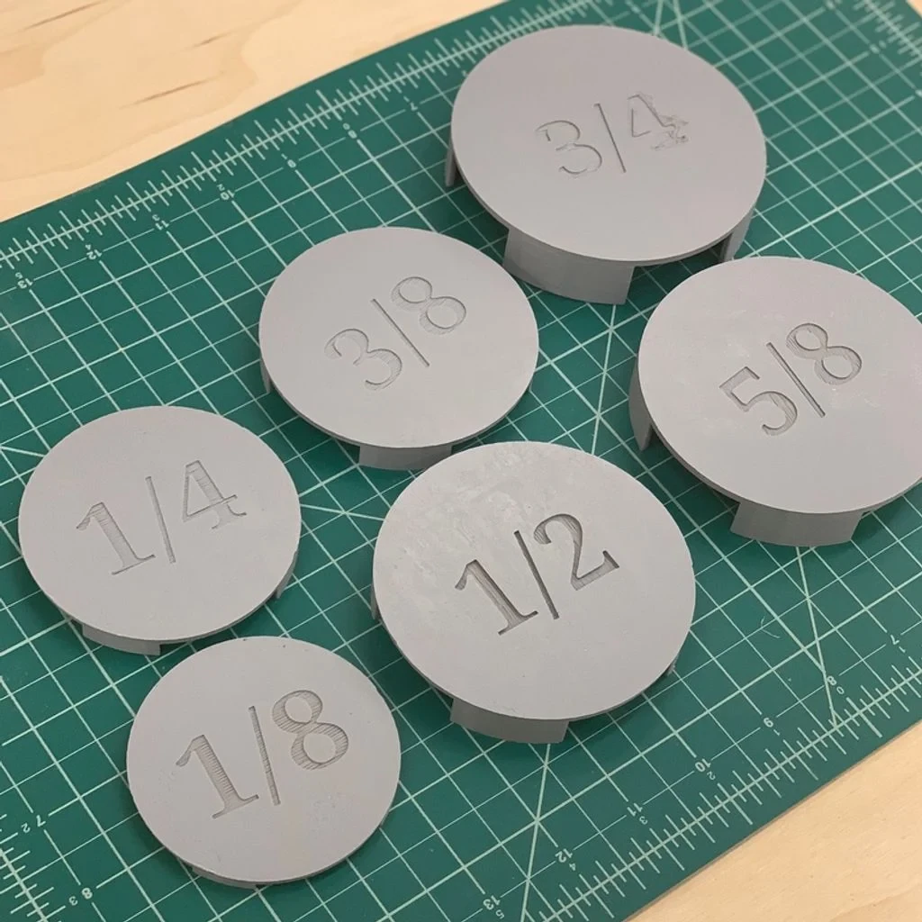 Six round printed depth gauges marked from 1/8 to 3/4 inch on a cutting mat