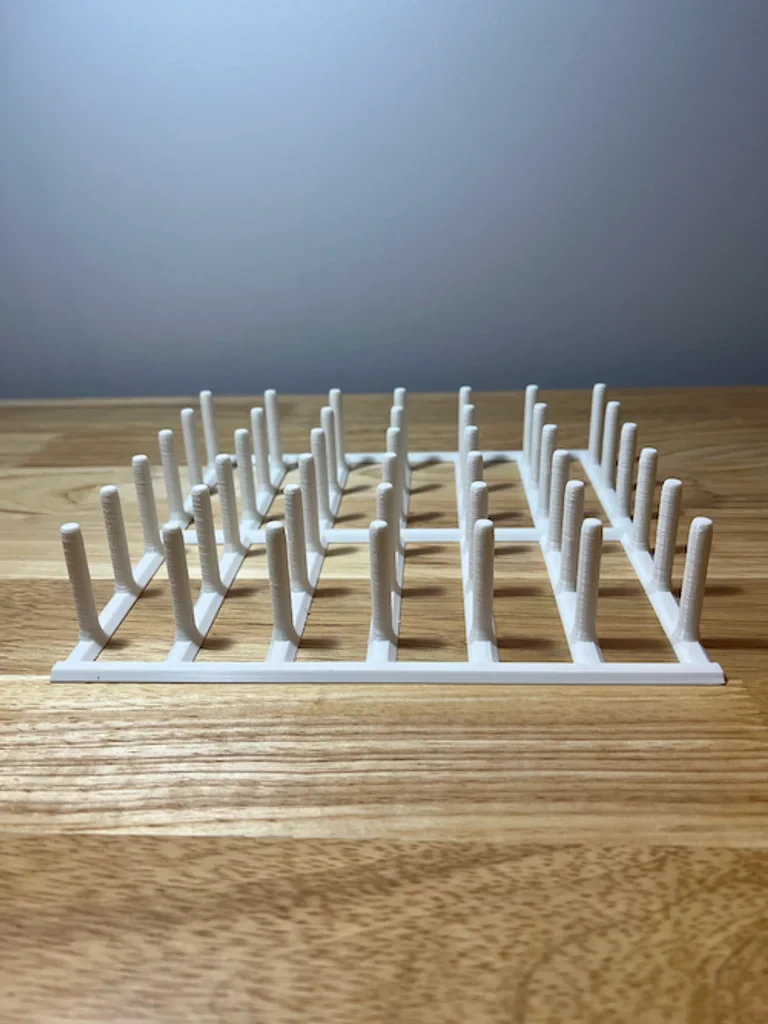 White printed sandwich bag drying rack with upright supports on a wooden table